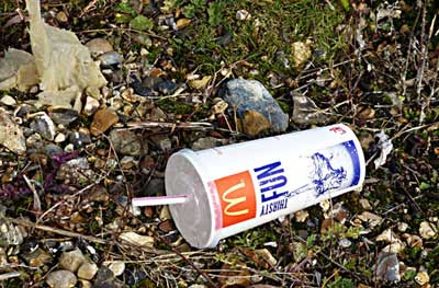 A dumped fast-food chain's cup with 'thirsty fun' written on it. It is not fun.